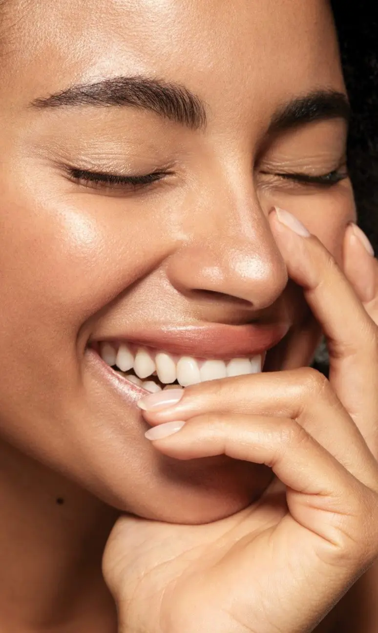 Happy client with glowing skin after a facial